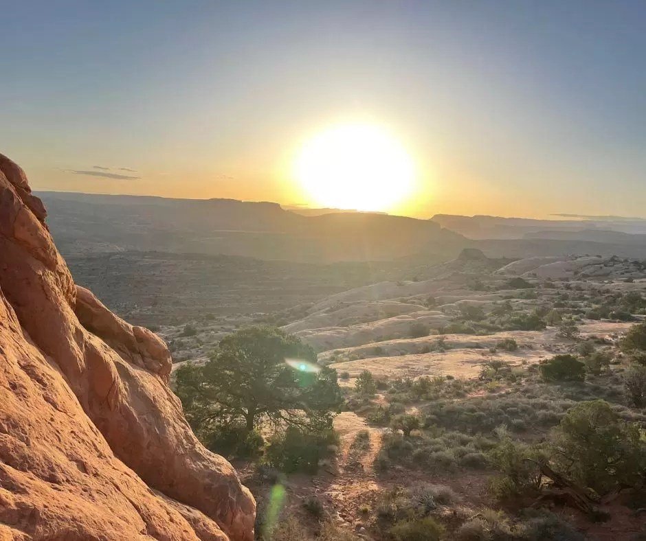 sunrise view from partition arch along devils garden trail in arches national park