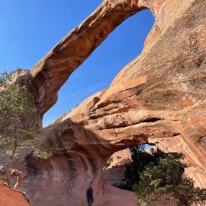 A man standing beneath double o arch at arches national park