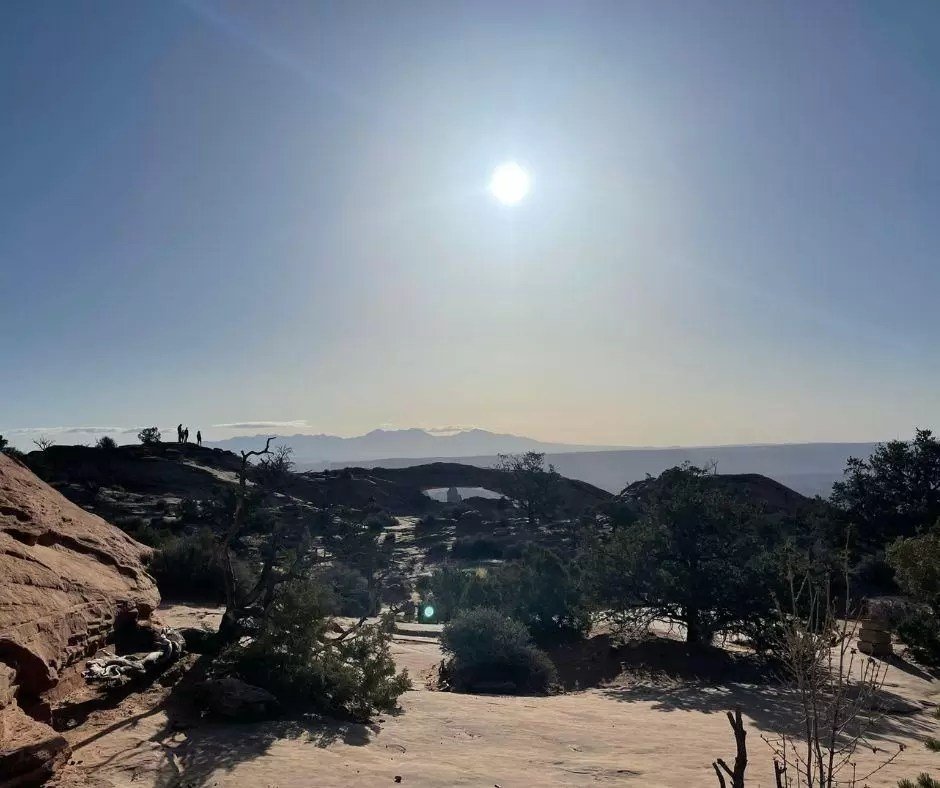 sunrise at mesa arch in canyonlands with la sal mountains in the distance