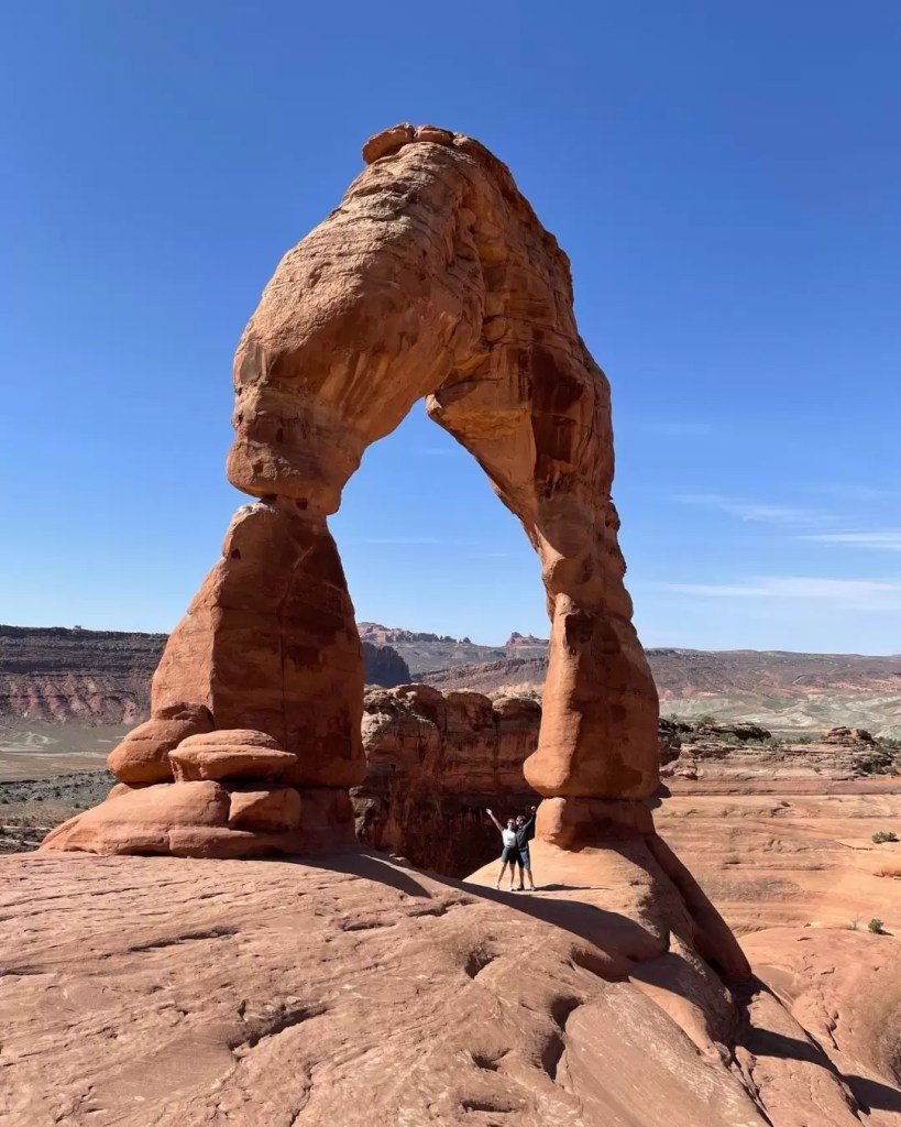 Couple standing under delicate arch