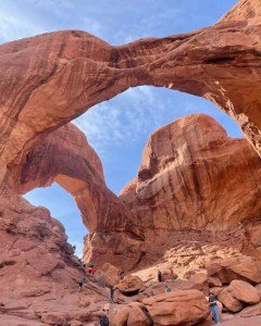 Double arch with tourists and hikers below