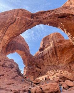 Double arch with tourists and hikers below