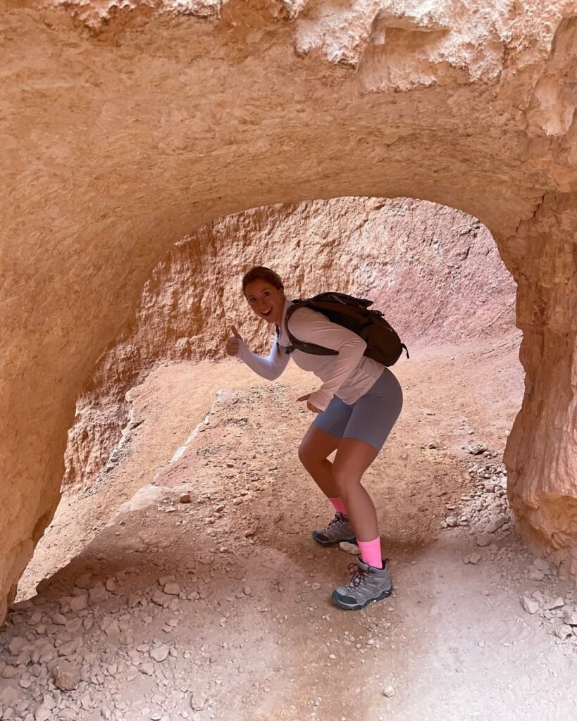 Woman going through small tunnel along Wall Street Trail at Bryce Canyon