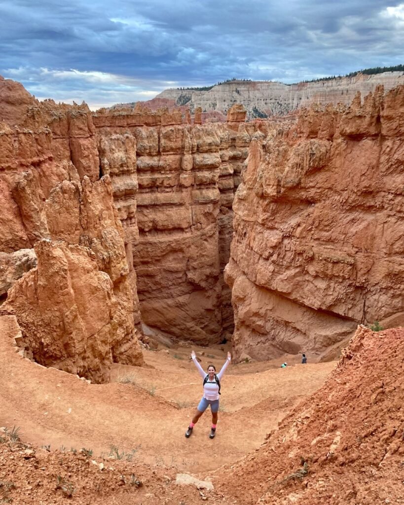 View into Wall Street's towering rocks with woman hiking along the trail